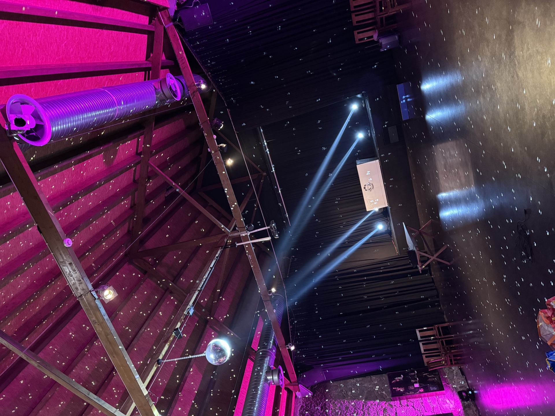 Festival venue lit in pink, with the dance floor and DJ booth